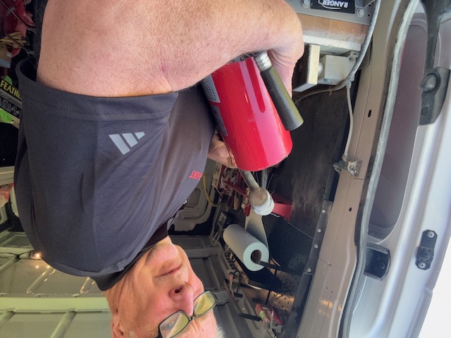 Brad Ayres inspecting an extinguisher inside the service van